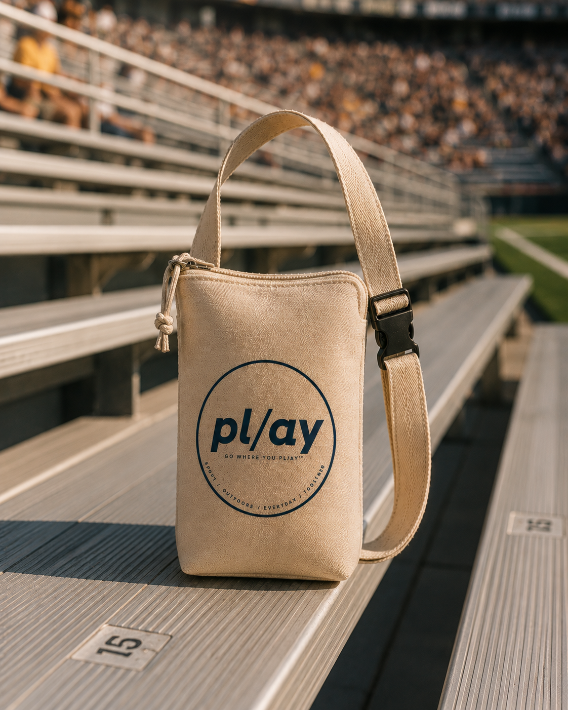 The PL/AY Bag — an everyday small bag designed around spectator and recreational life, sitting on stadium bleachers.